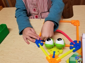 Youngster assembling a pieces to resemble the pattern on the card